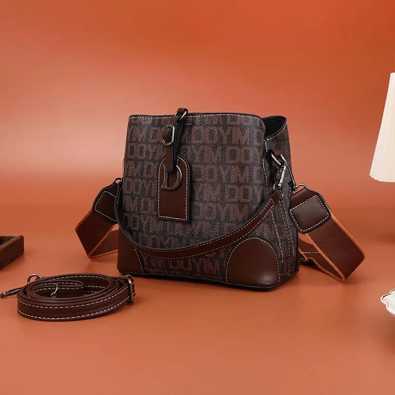 Brown leather handbag with visible branding on an orange background