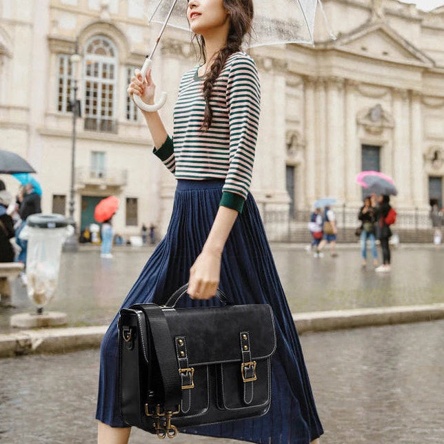 Woman holding a transparent umbrella in an urban setting with classical architecture.