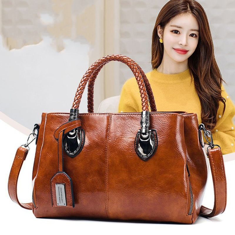 Brown handbag with a woman in a yellow sweater in the background