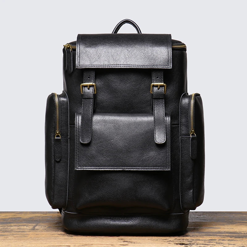 Black leather backpack on a wooden surface with a light gray background