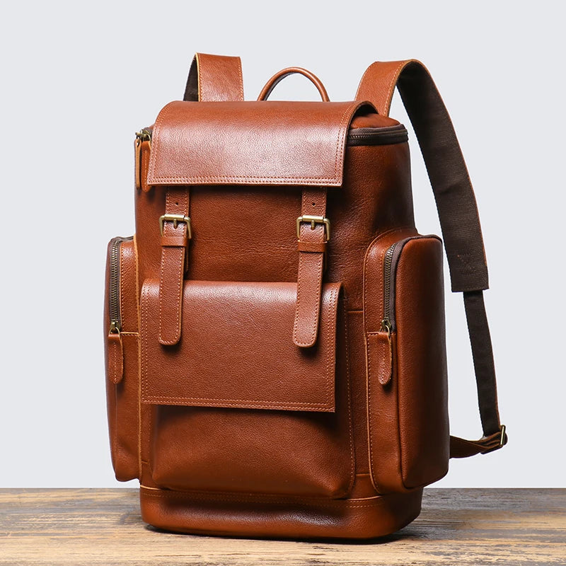 Brown leather backpack on a wooden surface with a light gray background