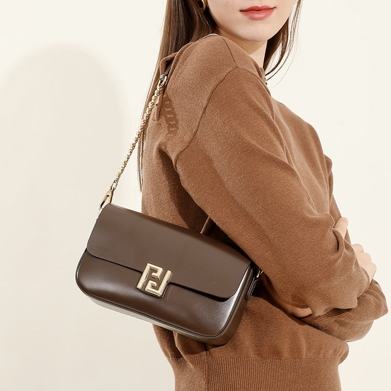 Woman wearing a brown sweater with a matching brown handbag on a beige background