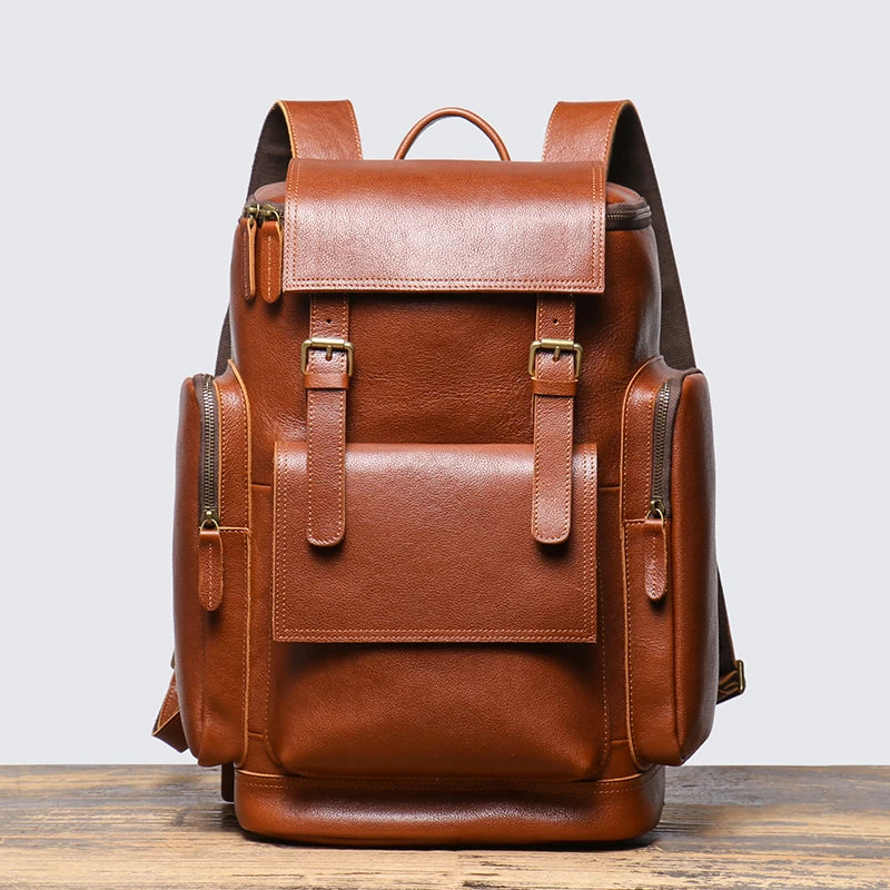 Brown leather backpack on a wooden surface with a light gray background