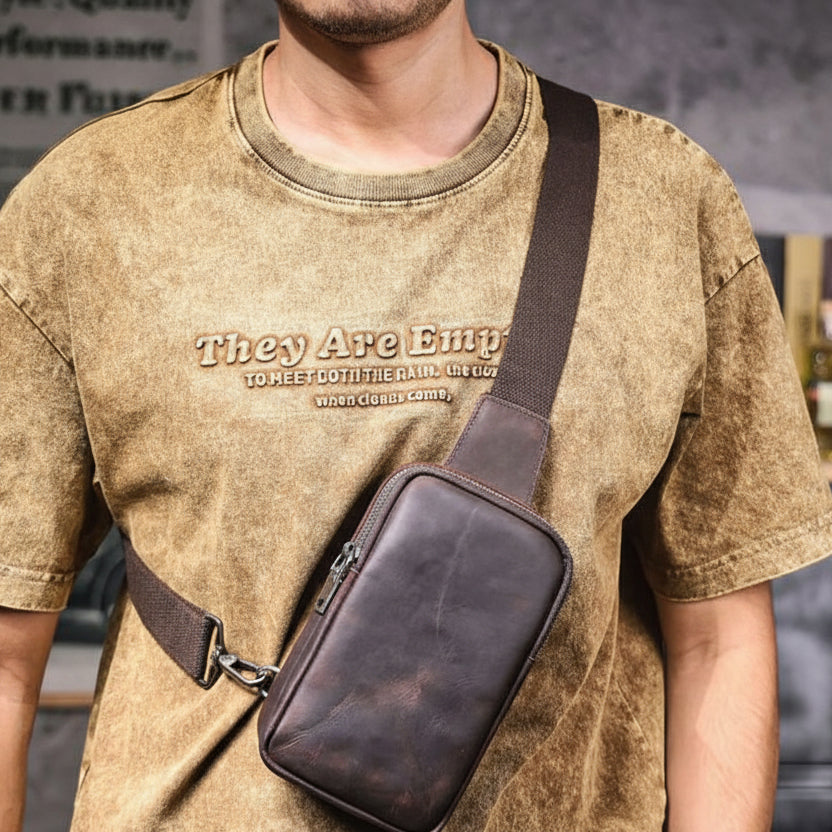 Person wearing a brown leather crossbody bag with 'S.WORKER' branding.