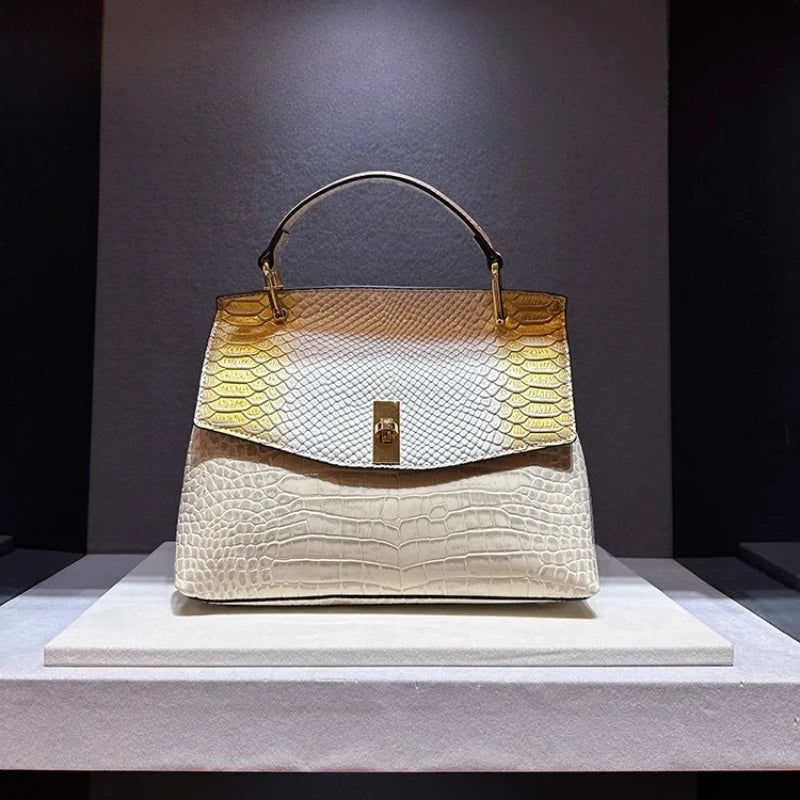 Designer handbag with gold accents on a gray platform