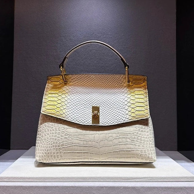 Designer handbag with gold accents on a gray platform